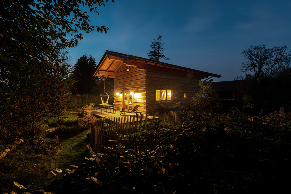 Aussenansicht Blockhaus in Abendstimmung mit Beleuchtung